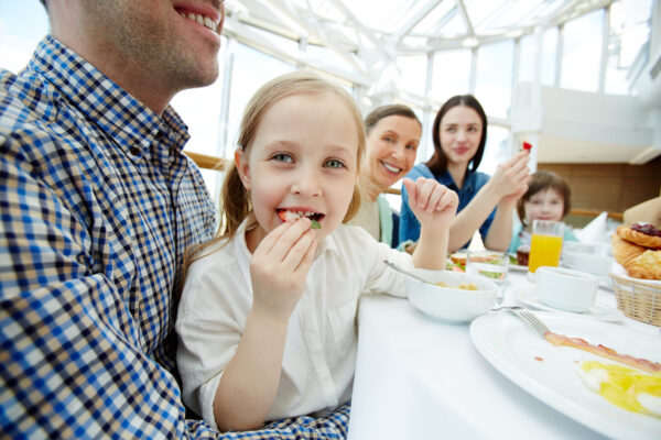 Happy child eating breakfast by festive table